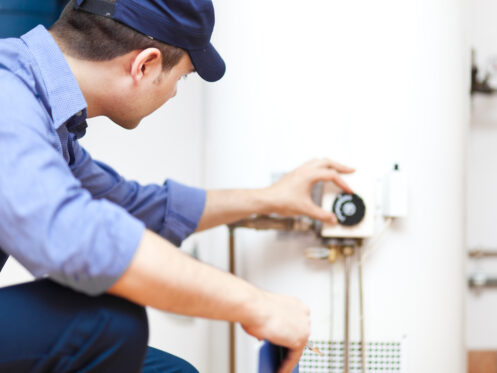 A man performing water heater maintenance, ensuring the system runs efficiently and extends the water heater lifespan. | High 5 Plumbing, Heating & Cooling